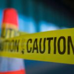 Yellow caution tape attached to traffic cone