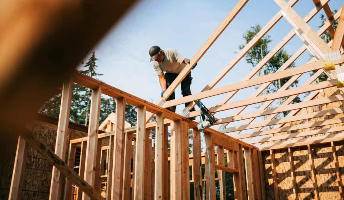 builder frames a house with lumber