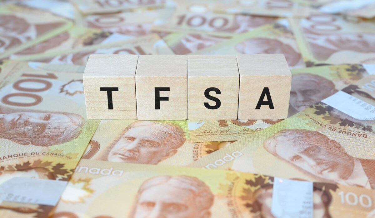 TFSA (Tax-Free Savings Account) on wooden blocks and Canadian one hundred dollar bills.