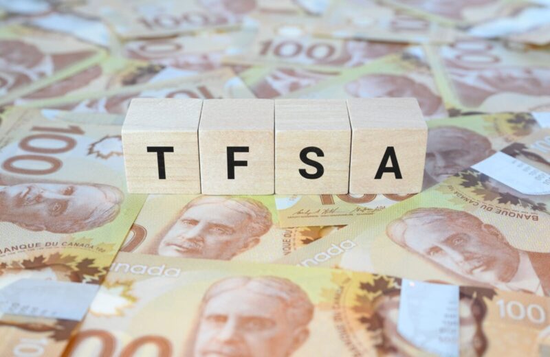 TFSA (Tax-Free Savings Account) on wooden blocks and Canadian one hundred dollar bills.
